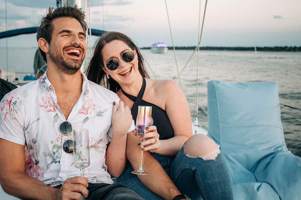 couple laughing together on a sailboat in charleston sc