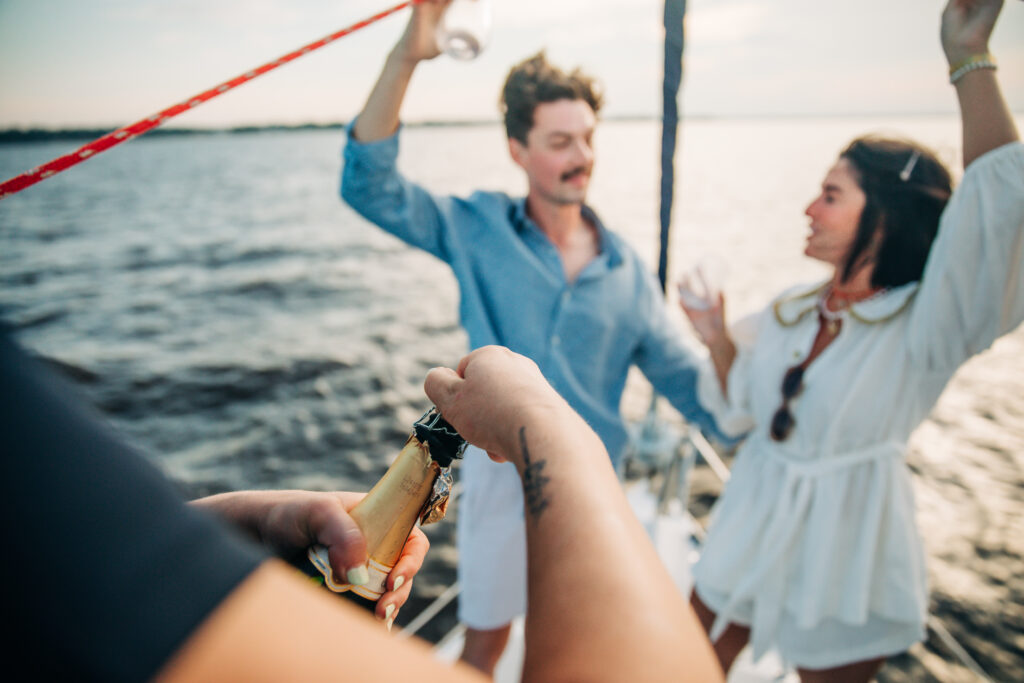 popping champagne on private sailboat tour in charleston sc with blue life charters