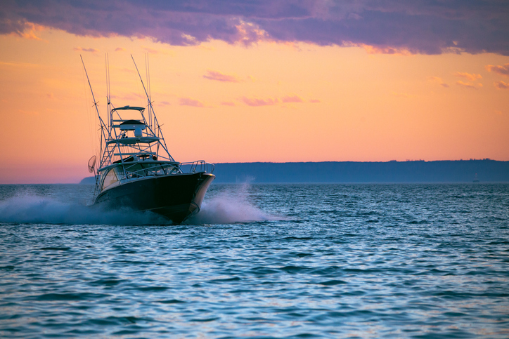 fishing yacht cruising at sunset