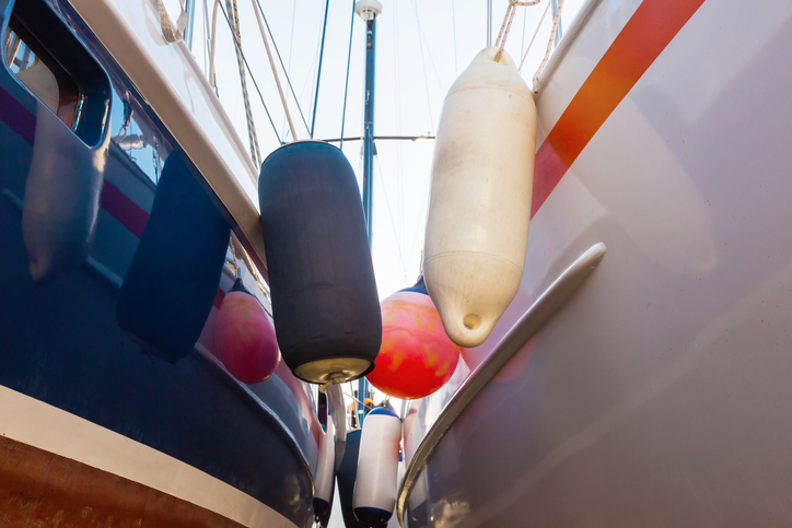 Two sail yachts huddled together on fenders.