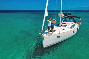 Young couple on anchored sailboat at Olib island, Croatia. View from drone.