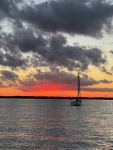 sunset in charleston with sailboat in background