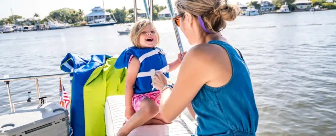 mom putting safety essentials for a boat experience in her child